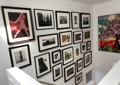 Gallery wall and large painting above stairs in Santa Monica home